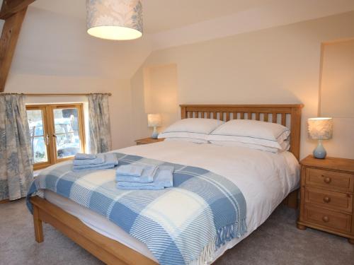 a bedroom with a bed with blue towels on it at 2 bed in Clovelly 56720 in Woolfardisworthy