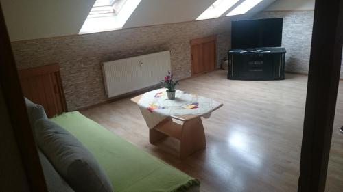 ein Wohnzimmer mit einem Tisch und einem TV in der Unterkunft Tolles Appartement in Hanau in Hanau am Main