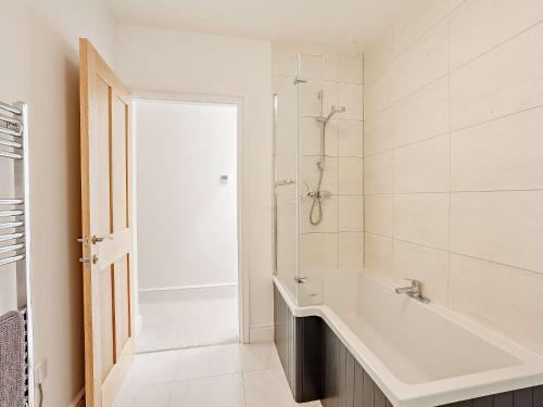 a white bathroom with a tub and a shower at 4 Bed in Illminster 83501 in Combe Saint Nicholas