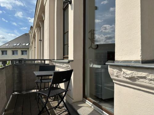 a balcony with two chairs and a table at MEOS 1 -Zentrum-Balkon-Parkplatz-Gym-Uniklinik in Leipzig