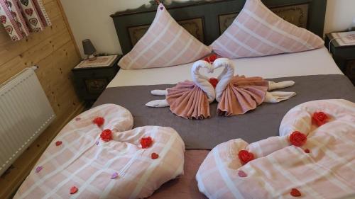 - un lit avec 4 serviettes en forme de cœur dans l'établissement Große Ferienwohnung in Nesselwängle, à Nesselwängle