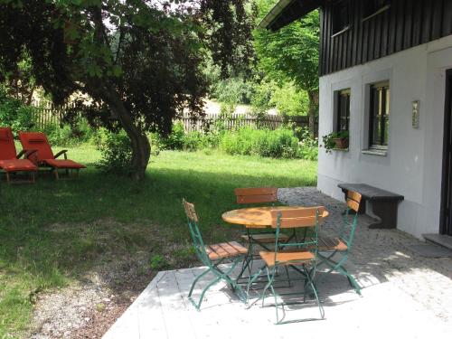 a table and chairs sitting outside of a house at Ferienhaus für vier Personen mit Sitzgelegenheit in Schöllnach