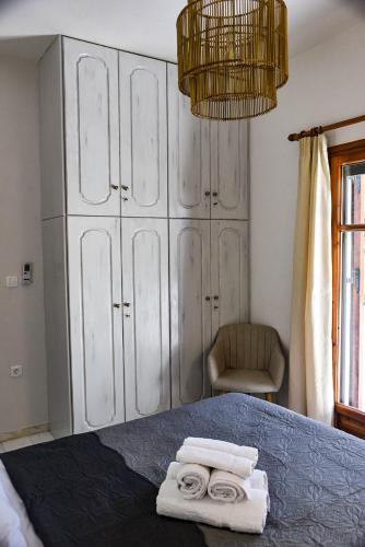a bedroom with a bed with two towels on it at DP Homes Santorini in Perissa