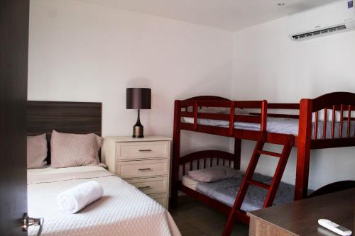 1 Schlafzimmer mit 2 Etagenbetten und einem Schreibtisch in der Unterkunft The Luxury Apartment in San Salvador