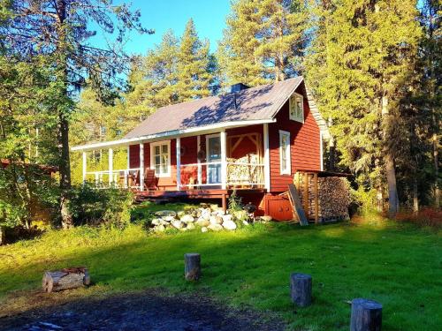 a small red house in the middle of a yard at Charmantes Ferienhaus in der Wildnis Lapplands in Blattniksele