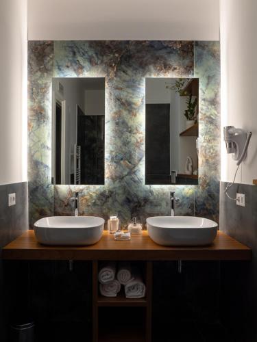 two sinks in a bathroom with two mirrors at Terra Mia in Piazza in Pompei