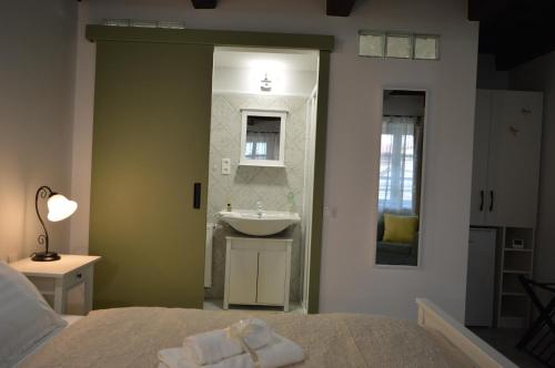 a bathroom with a bed and a sink and a mirror at NADIT Apartmanház in Hegykő