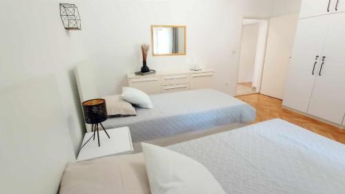 ein weißes Zimmer mit 2 Betten und einem Spiegel in der Unterkunft Studio für 6 Personen ca 90 qm in Marina, Dalmatien Kaštela und Umgebung - b53669 in Marina