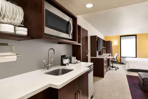 - une cuisine avec évier et un lit dans une chambre dans l'établissement Home2 Suites by Hilton Salt Lake City/Layton, à Layton