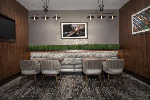 a restaurant with a bar with chairs and a tv at Embassy Suites Springfield in Springfield