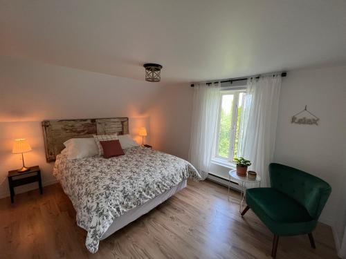 - une chambre avec un lit et une chaise verte dans l'établissement Gite - La ruée vers l'orge, à Trois-Rivières