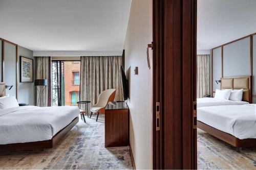 a hotel room with two beds and a desk at Hilton Gdansk in Gdańsk