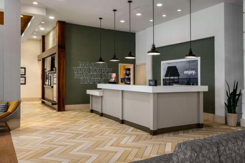 a lobby of a store with a counter and pendant lights at Hampton Inn & Suites San Juan in San Juan