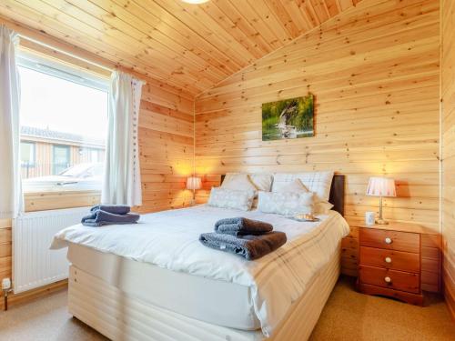 a bedroom with a bed in a wooden cabin at 2 Bed in Loch Leven 82297 in Kinross