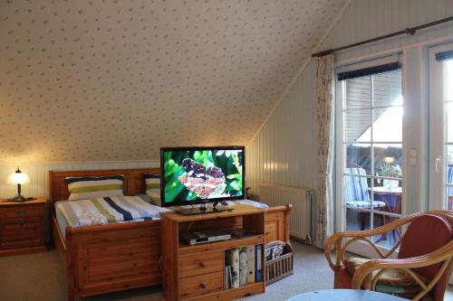 ein Schlafzimmer mit einem Bett und einem TV auf dem Tisch in der Unterkunft Kinderfreundliche Tolles Appartement in Altjührden mit Möblierter Terrasse in Varel