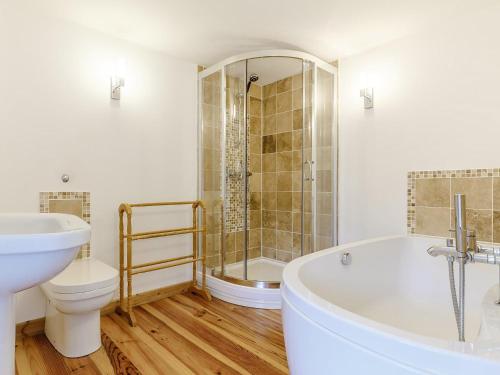 a bathroom with a tub and a toilet and a sink at 4 Bed in Bere Alston RTIDE in Tamerton Foliot