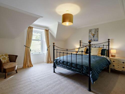 a bedroom with a bed and a chair and a window at 3 Bed in Biggar 82924 in Biggar