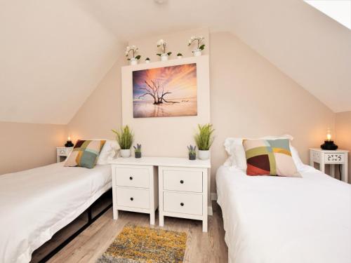 two beds in a attic room with white furniture at 2 Bed in Rothbury 82238 in Rothbury