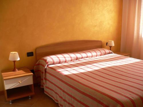 - une chambre avec un lit doté d'un couvre-lit rayé dans l'établissement Große Wohnung in Rosolina Mare mit Grill und Garten, à Rosolina Mare