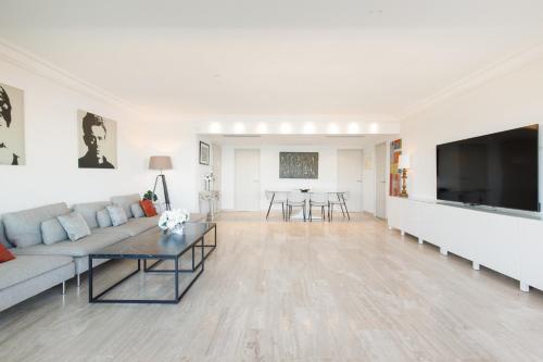un salon avec un canapé et une table dans l'établissement Élégant appartement 120m² en front de mer à Cannes, à Cannes