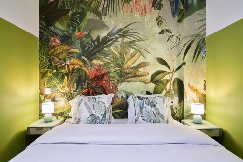 - une chambre avec un lit orné d'une fresque murale représentant des plantes dans l'établissement NG Prestige - Lille l Roubaix Trichon - Balnéo - Netflix - Wifi, à Roubaix