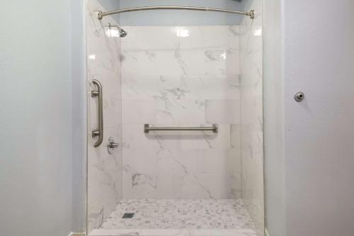 La salle de bains est pourvue d'une douche et de murs en marbre blanc. dans l'établissement Quality Inn Columbia, à Columbia