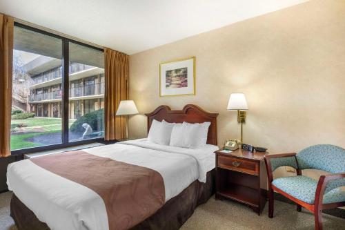 a hotel room with a bed and a chair and a window at Quality Inn Tysons Corner in Tysons Corner