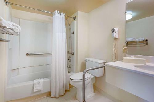 a bathroom with a toilet and a shower and a sink at Quality Inn Tysons Corner in Tysons Corner