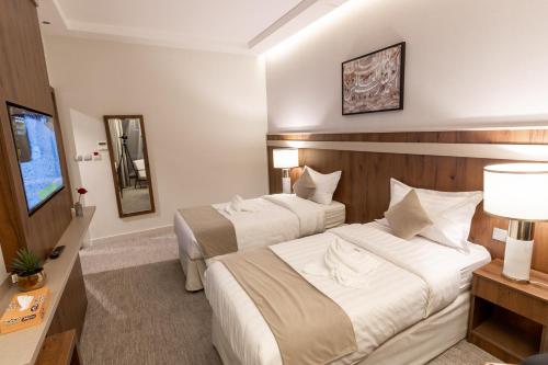 a hotel room with two beds and a television at Wassad Hotel Makkah in Makkah
