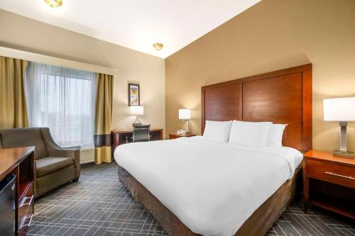 a hotel room with a large bed and a chair at Comfort Inn Airport Turfway Road in Florence