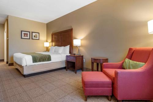um quarto de hotel com uma cama e uma cadeira em Comfort Inn Amite em Amite
