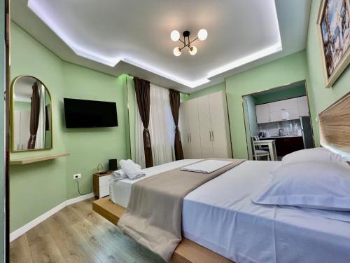 a bedroom with a large bed and a flat screen tv at Spiranca Apartments & Rooms in Tirana