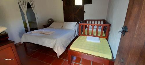 Habitación pequeña con cama y banco en Villa Helena, en San Gil