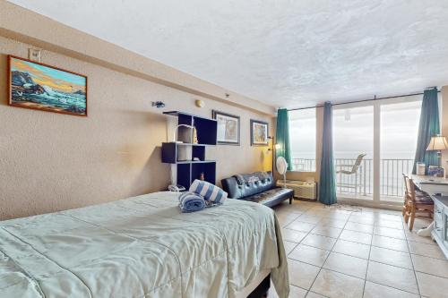 a bedroom with a bed and a couch and a desk at Harbour Beach Resort Unit 808 in Daytona Beach