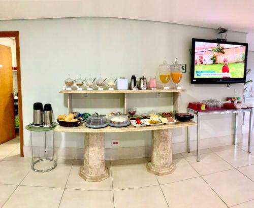 a room with a table with food on it at Hotel Flat Almaru - Marília in Marília