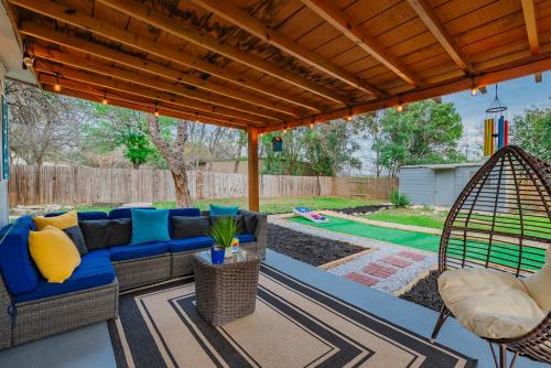 a patio with a blue couch under a pergola at Texas Vacation Home, Game Room & Pool By Sixflags in San Antonio