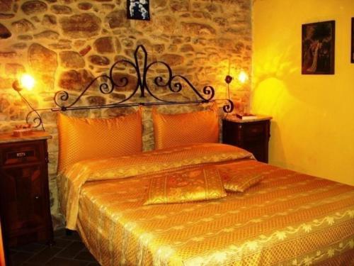 een bed in een kamer met een stenen muur bij Ferienwohnung in einem toskanischen Landhaus, mit privater Panoramaterrasse in Poppi