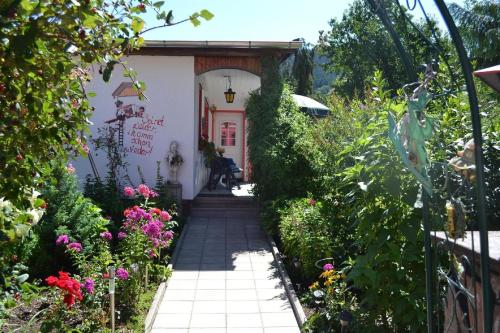 een tuinpad dat leidt naar een huis met bloemen bij Ferienhaus für drei Personen mit Terrasse in Friedrichroda