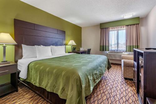 a hotel room with a large bed and a window at Quality Inn in New London