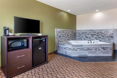 a bathroom with a tub and a flat screen tv at Quality Inn in New London
