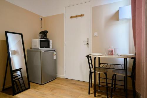 - une petite cuisine avec une petite table et un four micro-ondes dans l'établissement NG Prestige - Lille l Roubaix Trichon - Netflix - Wifi, à Roubaix
