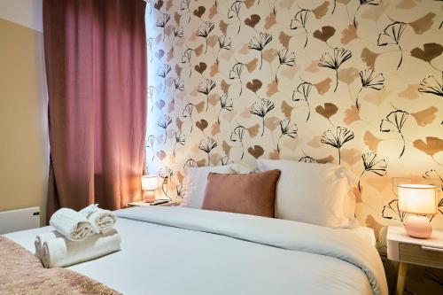 une chambre avec un lit avec un papier peint fleuri dans l'établissement NG Prestige - Lille l Roubaix Trichon - Netflix - Wifi, à Roubaix