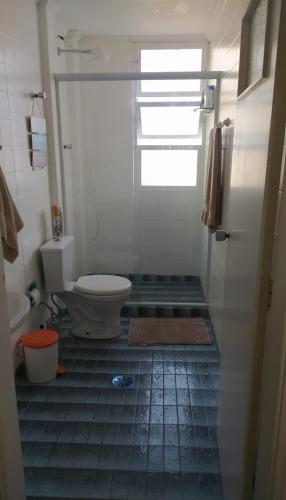 a bathroom with a toilet and a glass shower at Pé na Areia em Santos in Santos