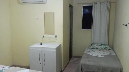 a small bathroom with a sink and a mirror at POUSADA LELÊ CONVENÇÕES in Recife