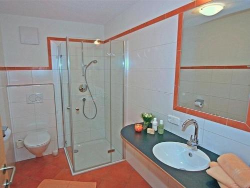 uma casa de banho com um chuveiro, um lavatório e um WC. em Komfortable Ferienwohnung mit zwei Doppelzimmern und zwei Badezimmern em Schröcken