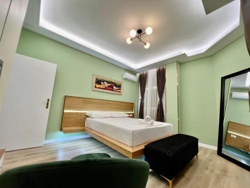 a bedroom with a bed and a chair and a ceiling at Spiranca Luxury Suites in Tirana