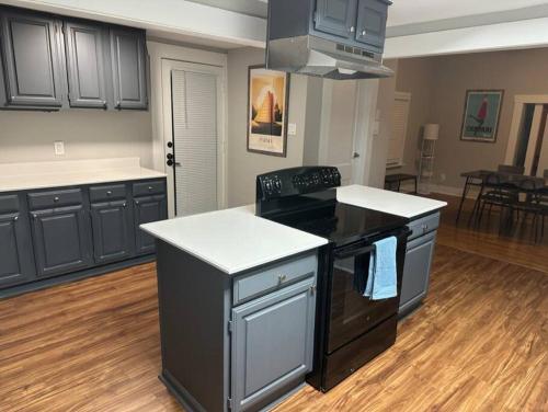 a kitchen with black cabinets and a stove top oven at Luxury Stay in Montrose- Parma _ the Italian Plaza in Houston