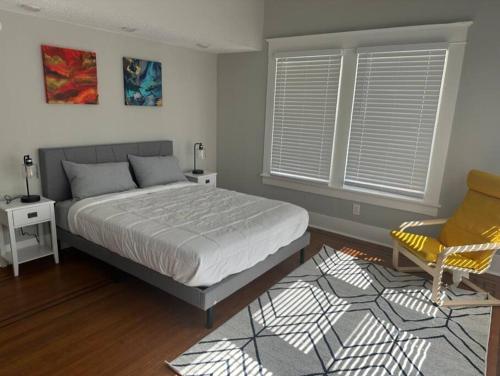 1 dormitorio con 1 cama y 1 silla amarilla en Luxury Stay in Montrose- Parma _ the Italian Plaza en Houston