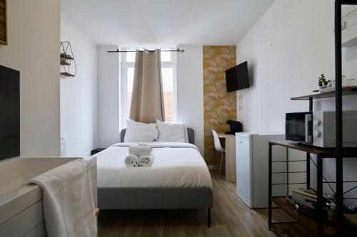 une chambre avec un lit avec deux serviettes dessus dans l'établissement NG Prestige l Lille l Roubaix Gare l Cassel - Netflix - Wifi, à Roubaix