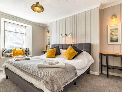ein Schlafzimmer mit einem großen Bett mit gelben Kissen in der Unterkunft 1 Bed in Wadebridge 87740 in Wadebridge